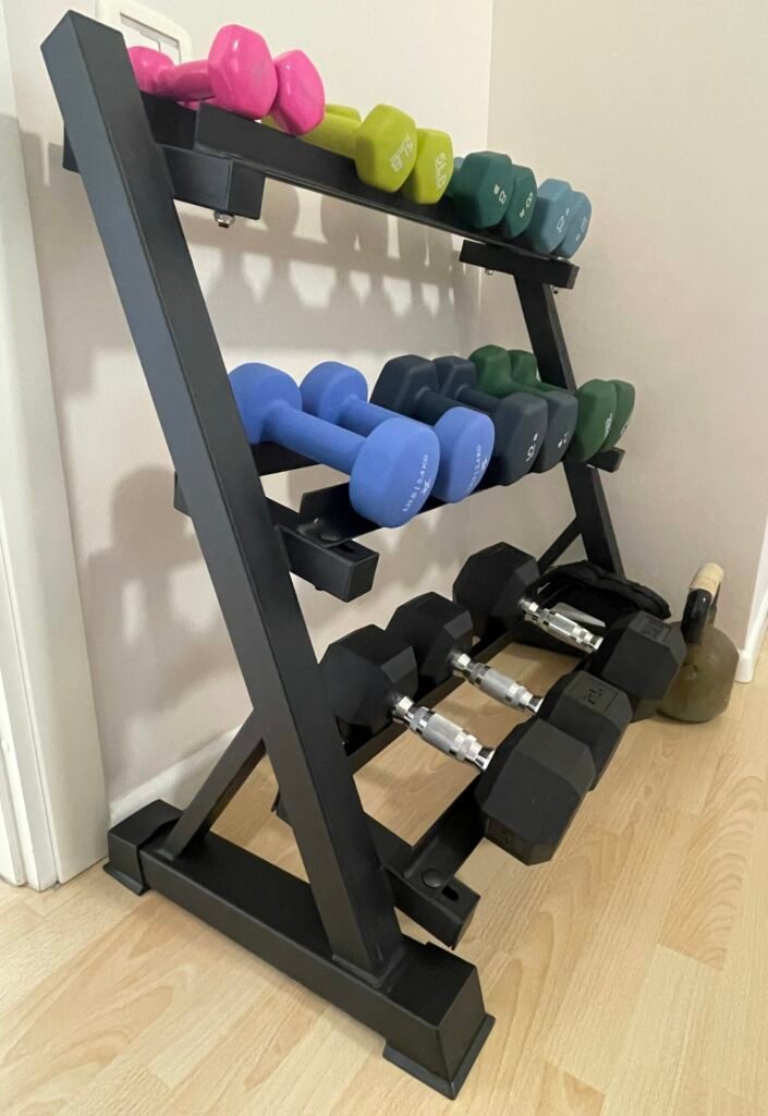 Dumbbells organized on a compact rack in a small space home gym setup