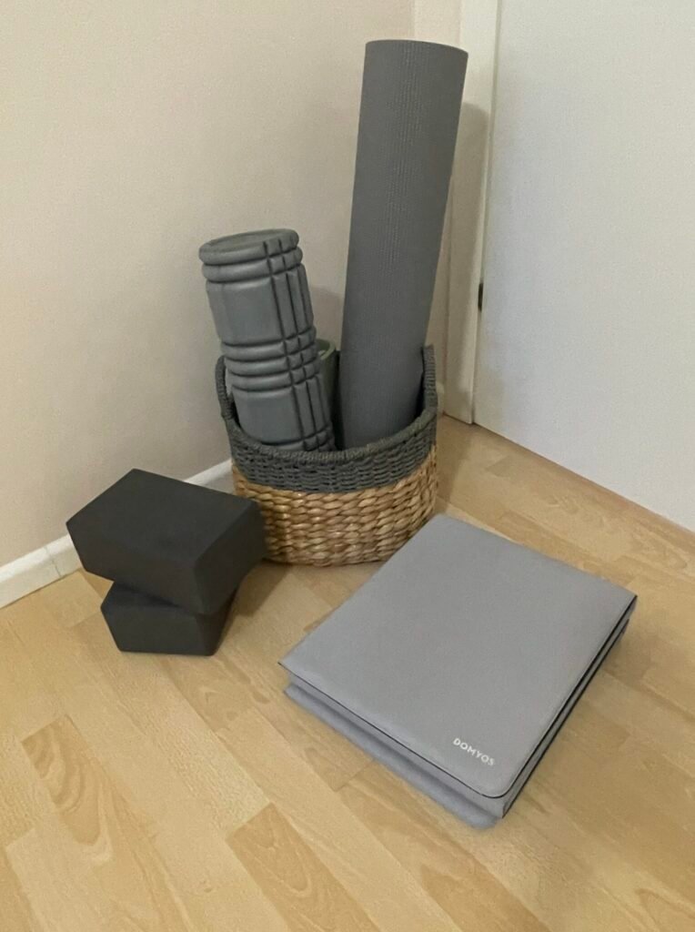 Yoga mat, yoga blocks, and woven basket storage in a small home workout space